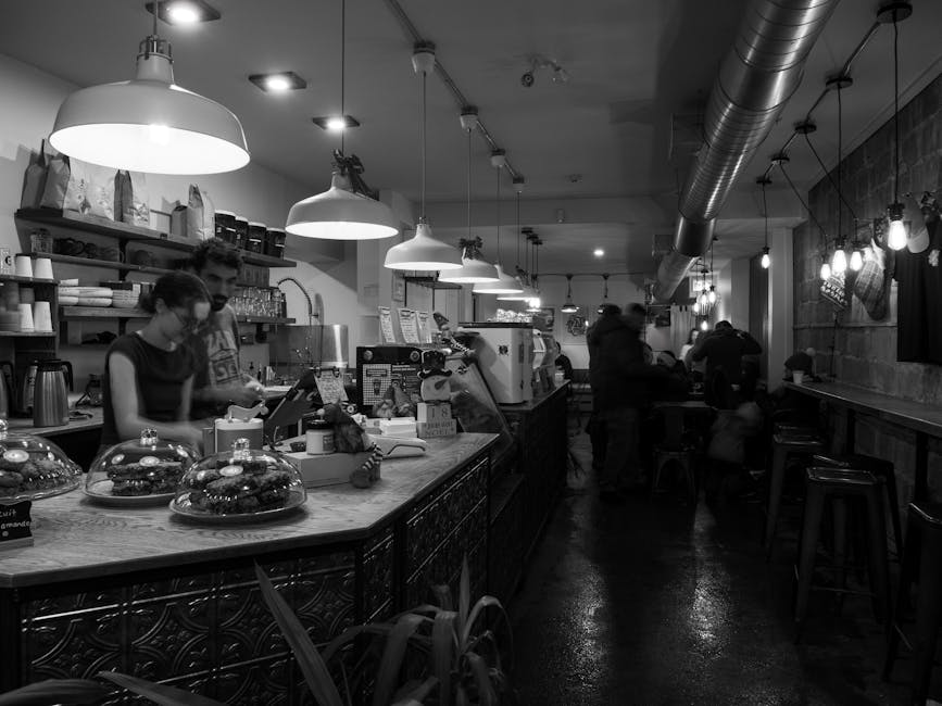 Cozy café in black and white, showcasing a bustling coffee shop interior with people working and relaxing.