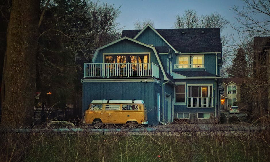 Picturesque blue house in Markham, Canada with a vintage yellow van. Sunset view capturing suburban tranquility.