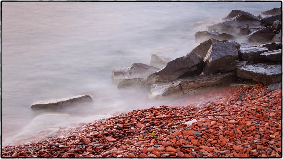 Tranquil shoreline with mist over rocks and pebbles, Mississauga, Canada. Captured in a calm, reflective moment.