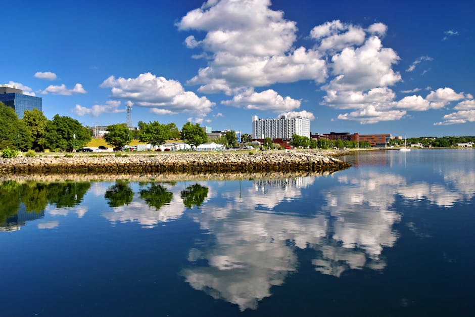 Beautiful summer view of Sydney, Nova Scotia's waterfront with clear reflections and blue sky.