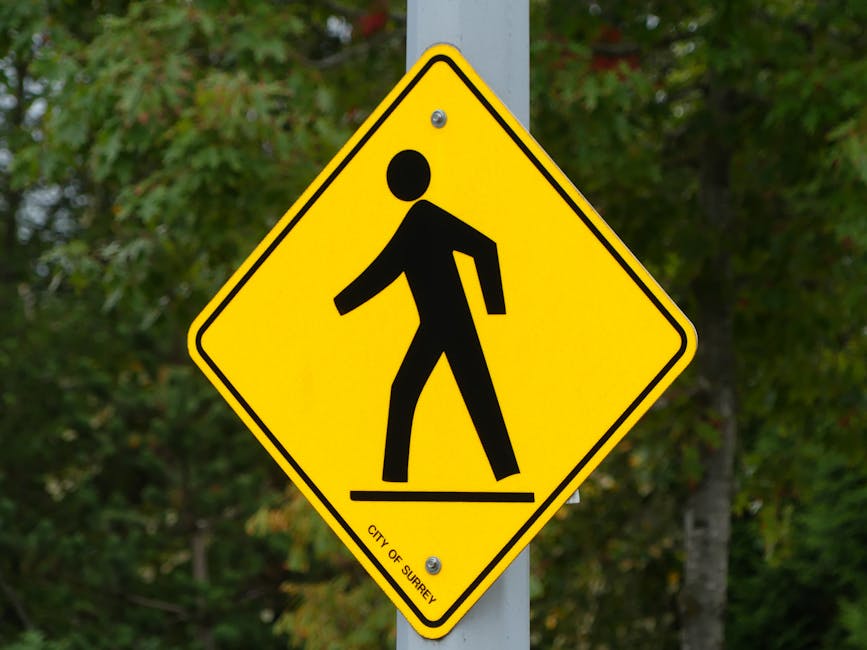 Vibrant yellow pedestrian crossing sign in Surrey, emphasizing safety.