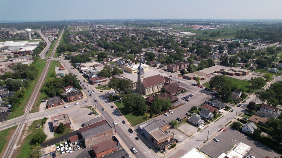 Aerial cityscape of Windsor, Ontario, showing buildings, roads, and green spaces.
